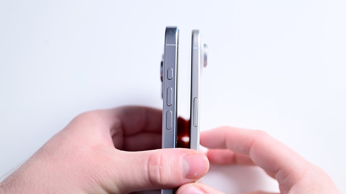 Two hands holding two smartphones side-by-side, displaying differing thicknesses and buttons against a plain white background.