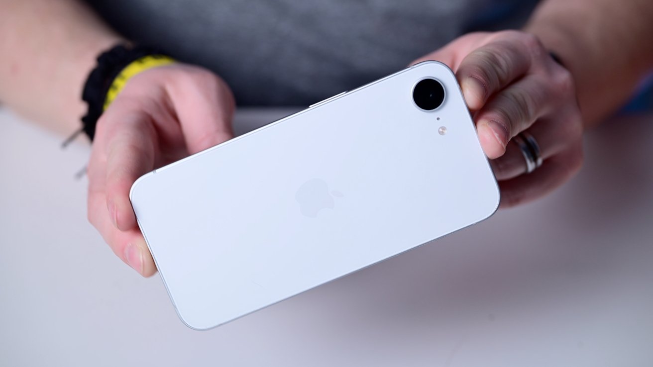 Holding a white smartphone to the camera