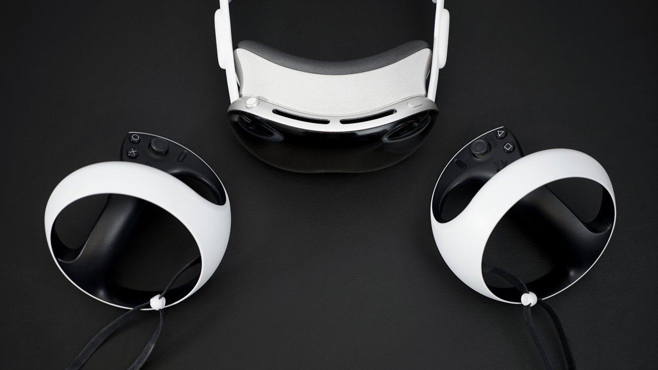 A VR headset and two white controllers with black grips are positioned on a dark surface.