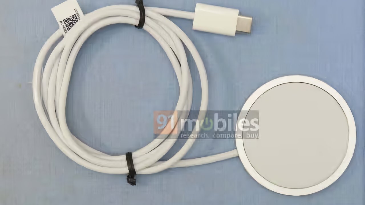White coiled charging cable with USB-C connector and magnetic round charging pad on a blue surface. Branding watermarked over the charging pad.