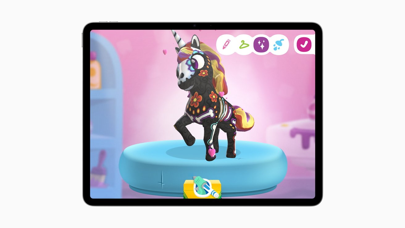 Colorful toy unicorn with floral and skeletal designs standing on a blue platform. The background is pink with various icons displayed at the top.